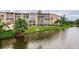 Well-maintained building exterior featuring manicured lawn, mature palms, and water views at 3635 Lake Bayshore Dr # J-410, Bradenton, FL 34205