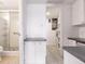 Hallway leading to a bathroom with a glass-enclosed shower and a storage area at 3635 Lake Bayshore Dr # J-410, Bradenton, FL 34205