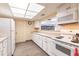Well-lit kitchen featuring white appliances, ample cabinet space, and a pass-through window at 3635 Lake Bayshore Dr # J-410, Bradenton, FL 34205
