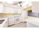 Bright kitchen featuring white cabinets, modern appliances, light countertops and a ceiling fan at 3635 Lake Bayshore Dr # J-410, Bradenton, FL 34205