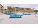 Well-maintained community pool with sun loungers and umbrellas against a condo backdrop at 3635 Lake Bayshore Dr # J-410, Bradenton, FL 34205