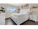 Bright bedroom with hardwood floors, white furniture, and view of palm trees at 3850 Catalina Dr, Bradenton, FL 34210