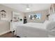 Bright bedroom with white furniture, ceiling fan, and view of palm trees at 3850 Catalina Dr, Bradenton, FL 34210