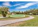 Aerial view of a community green space with a putting green, a gazebo and lush landscaping and sidewalks at 3850 Catalina Dr, Bradenton, FL 34210