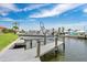View of a boat on a boat lift, and waterfront homes in the background against a pretty blue sky at 3850 Catalina Dr, Bradenton, FL 34210
