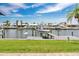 Gorgeous waterfront view featuring a boat lift, and nicely landscaped lawn against a blue sky with white clouds at 3850 Catalina Dr, Bradenton, FL 34210