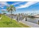 Beautiful waterfront view featuring boat dock and lift, a waterway, and lovely landscaping against a blue sky at 3850 Catalina Dr, Bradenton, FL 34210