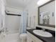 Bathroom features white tiling, shower over tub, and a modern mirror at 401 N Bay Blvd, Anna Maria, FL 34216