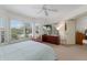 Light-filled bedroom with large windows, ceiling fan, and wall-mounted television at 401 N Bay Blvd, Anna Maria, FL 34216