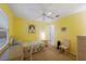 Cozy bedroom with bright yellow walls, wicker furniture, and ceiling fan at 401 N Bay Blvd, Anna Maria, FL 34216