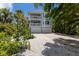 Two-story home with a two-car garage, balcony, and lush landscaping at 401 N Bay Blvd, Anna Maria, FL 34216