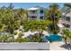 Beautiful two-story home with balconies, lush landscaping, and a unique turquoise gate at 401 N Bay Blvd, Anna Maria, FL 34216