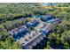 Overhead view of blue townhomes within a tree-lined community, featuring a serene pond at 4532 Chinkapin Dr, Sarasota, FL 34232