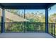 A screened balcony with a black metal railing overlooks greenery and trees at 4532 Chinkapin Dr, Sarasota, FL 34232