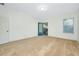 Bright bedroom with beige carpet, a ceiling light, and doors to a balcony and window at 4532 Chinkapin Dr, Sarasota, FL 34232