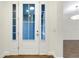 A white front door with glass panels, wood-look floors, and neutral walls at 4532 Chinkapin Dr, Sarasota, FL 34232