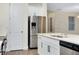 Modern kitchen with stainless steel refrigerator, white cabinetry, and quartz countertops at 4532 Chinkapin Dr, Sarasota, FL 34232