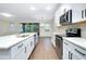 Open kitchen features quartz counters, stainless appliances, white cabinetry and flows to dining and outdoor space at 4532 Chinkapin Dr, Sarasota, FL 34232