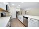 Bright kitchen features white cabinets, stainless steel appliances, quartz counters, and wood-look flooring at 4532 Chinkapin Dr, Sarasota, FL 34232