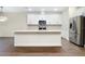 Kitchen featuring white cabinetry, a stainless steel refrigerator, and an island with stone countertops at 4532 Chinkapin Dr, Sarasota, FL 34232