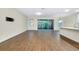 Open-concept living space with wood-look tile floors, sliding glass doors, and adjacent kitchen area at 4532 Chinkapin Dr, Sarasota, FL 34232