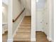 Bright stairway with a wooden handrail and a nearby half-bathroom features wood-look flooring at 4532 Chinkapin Dr, Sarasota, FL 34232