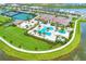 Aerial view of the community pool area featuring various pools, palms, cabanas, and a clubhouse at 4915 Kiva Cir, Bradenton, FL 34211