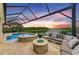 Gorgeous backyard featuring a pool, jacuzzi, outdoor seating, and a serene view of the lake at sunset at 4915 Kiva Cir, Bradenton, FL 34211