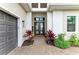 Inviting front entrance featuring a brick pathway, double doors, a two car garage, and colorful landscaping at 4915 Kiva Cir, Bradenton, FL 34211
