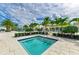 Beautiful outdoor jacuzzi tub surrounded by palm trees and pool area with white stone pavers at 4915 Kiva Cir, Bradenton, FL 34211