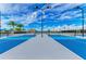 Brightly colored blue tennis courts with black posts surrounded by dark, tall lamp posts at 4915 Kiva Cir, Bradenton, FL 34211