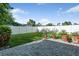 Backyard featuring a stone patio, lush grass, and white fence and mature greenery at 5206 19Th W Ave, Bradenton, FL 34209
