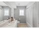 Bright bathroom featuring neutral walls, tiled floor, white fixtures, and a shower-tub combo with white shower curtain at 5206 19Th W Ave, Bradenton, FL 34209