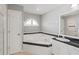 Corner bathtub, sink, and door in the bathroom with dark countertop at 5206 19Th W Ave, Bradenton, FL 34209