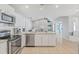 Bright, open kitchen featuring stainless steel appliances, white cabinets, and tile flooring at 5206 19Th W Ave, Bradenton, FL 34209