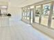 Enclosed sunroom with bright white interior, tiled floors, bar, and large windows overlooking the backyard at 544 Mount Vernon Dr, Venice, FL 34293