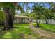 The house with a spacious backyard and a covered patio surrounded by mature trees at 5702 Tangerine S Ave, Gulfport, FL 33707