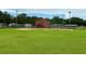 Well-kept baseball field with a green lawn and a red building at the back, fenced in and ready for play at 5702 Tangerine S Ave, Gulfport, FL 33707