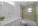 Bathroom features a white vanity with marble countertop, toilet, and shower with light beige tile surround at 5702 Tangerine S Ave, Gulfport, FL 33707
