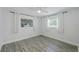Well-lit bedroom with wood-look floors, two windows, a ceiling fan and light, airy feel at 5702 Tangerine S Ave, Gulfport, FL 33707
