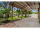 Large carport with a gravel base, surrounded by lush landscaping and a white fence at 5702 Tangerine S Ave, Gulfport, FL 33707