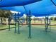 Green exercise equipment beneath a blue canopy, perfect for outdoor fitness activities in a community park at 5702 Tangerine S Ave, Gulfport, FL 33707
