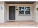 Elegant front door with decorative glass, framed by sconces and a window, set against a brick facade at 5702 Tangerine S Ave, Gulfport, FL 33707