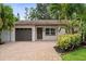 Inviting single-story home featuring a brick driveway, garage, and decorative front door at 5702 Tangerine S Ave, Gulfport, FL 33707
