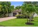 Landscaped front yard with a well-maintained lawn and a paved driveway leading to the garage at 5702 Tangerine S Ave, Gulfport, FL 33707