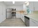 Modern kitchen features stainless steel appliances, white cabinets, and light-toned wood-look flooring at 5702 Tangerine S Ave, Gulfport, FL 33707