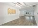 Spacious living area offering modern light fixture, sleek wood floors, and abundant natural light at 5702 Tangerine S Ave, Gulfport, FL 33707