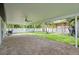 Open, covered patio with brick pavers, offering a serene backyard with mature palms at 5702 Tangerine S Ave, Gulfport, FL 33707