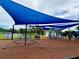 Colorful playground with climbing structures under a blue shade, featuring a climbing net and play equipment at 5702 Tangerine S Ave, Gulfport, FL 33707
