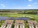 Stunning aerial view of the community with lush golf course, pond, and beautiful homes in a desirable neighborhood at 5916 Wake Forest Run # 101, Bradenton, FL 34211